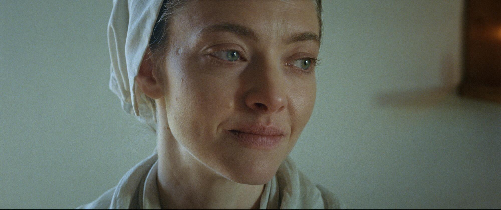 A woman in a white cap smiles.