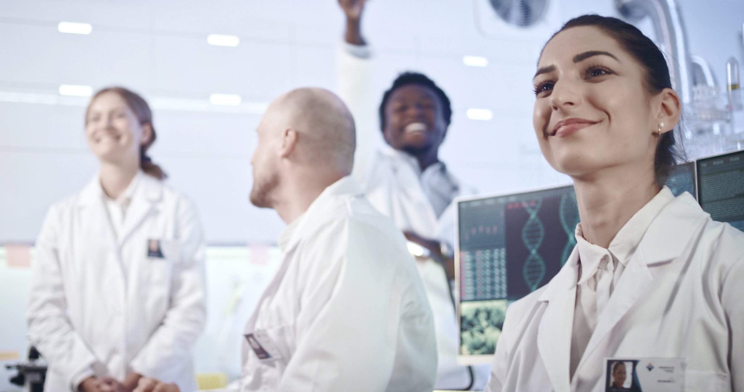 Researchers smile in a lab setting.