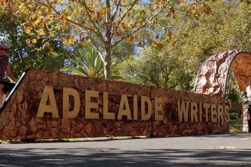 A temporary fence with the words ADELAIDE WRITERS on it