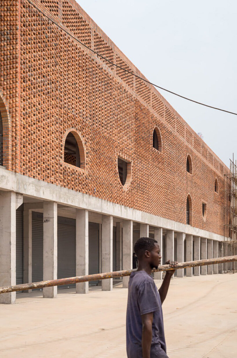 concrete canopies and porous brick walls form central market redevelopment in congo