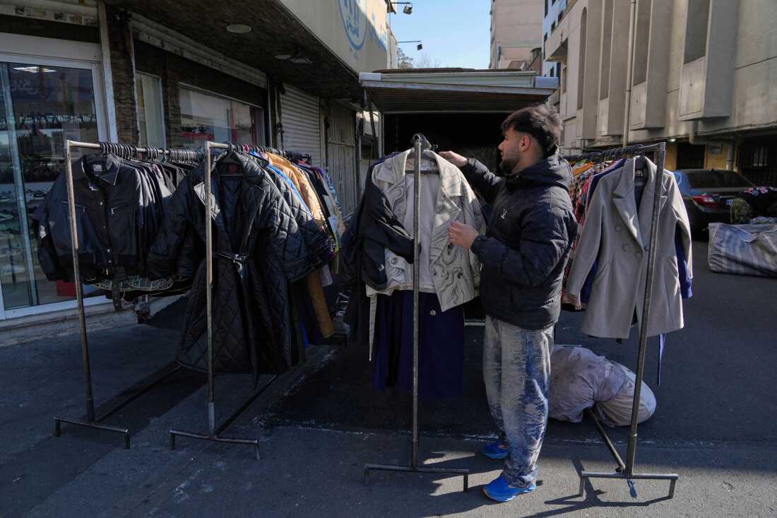 A street vendor adjusts clothes for sale in downtown Tehran, Iran, on Friday.
