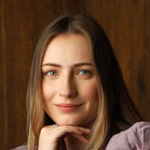 Blonde woman wearing a purple blouse with wooden background