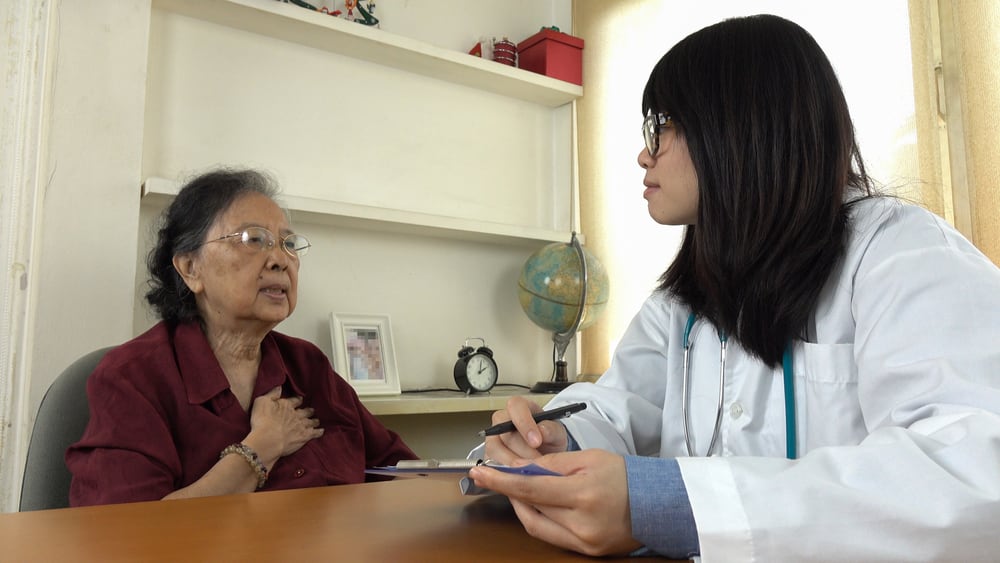 older woman speaking to a doctor while they are facing each other sitting down diagonally 