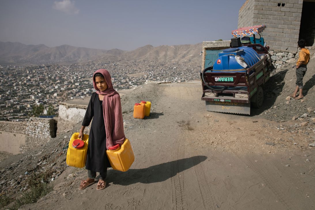 A girl with canisters of water from a water truck, on September 17, 2025 in Kabul, Afghanistan. The city of six million people could run out water by 2030, some experts say.