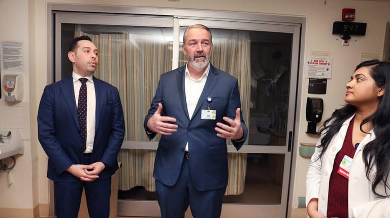 Thomas Stokes, center, with NuHealth Surgery physician David Parizh, left,...