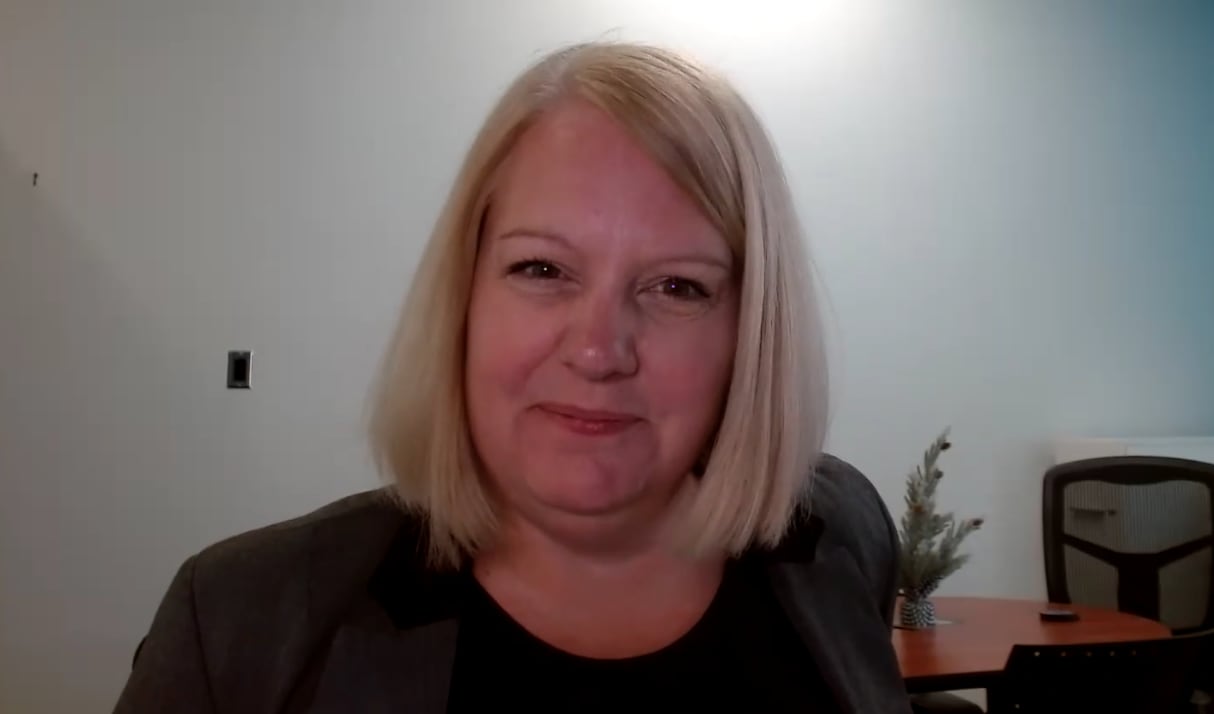 A woman smiles at the camera.