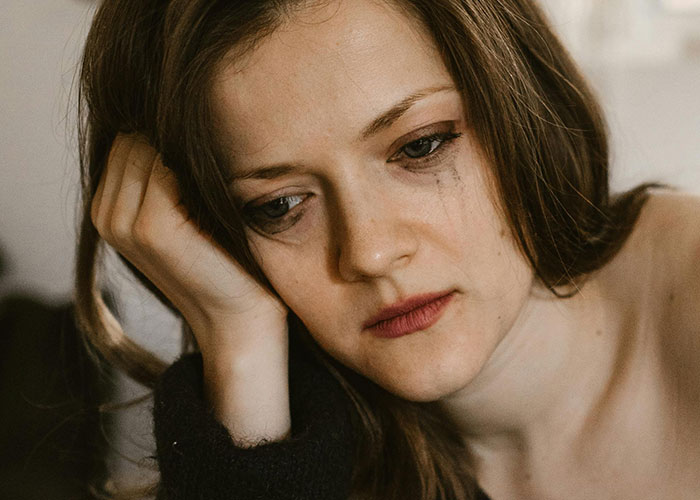 Young woman with tears and smudged makeup feeling upset, reflecting the worst things medical professionals have said to patients.