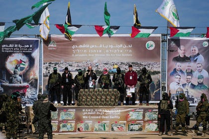 Three hostages held in Gaza, from left, Sagui Dekel Chen, Iair Horn and Sasha Troufanov, are escorted by Hamas and Islamic Jihad fighters as they are handed over to the Red Cross in Khan Younis, in February 2025.