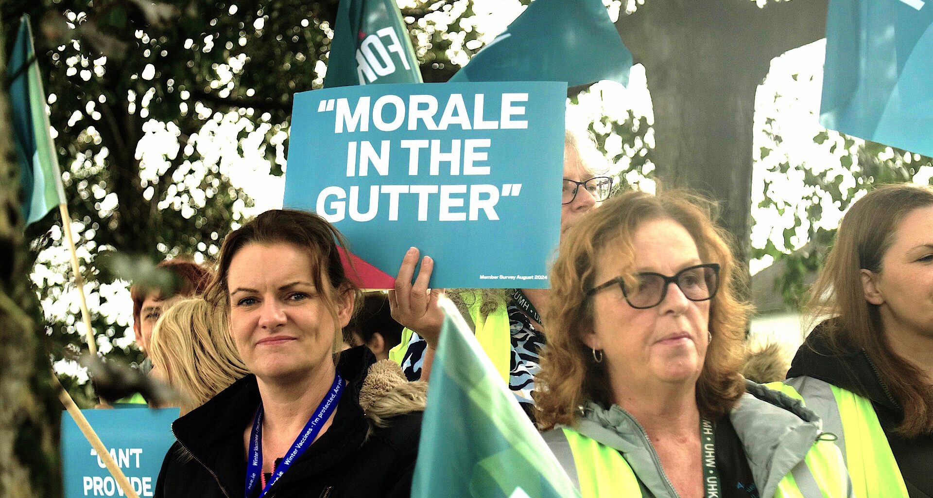 two forsa members at a protest holding a sign saying morale in the gutter