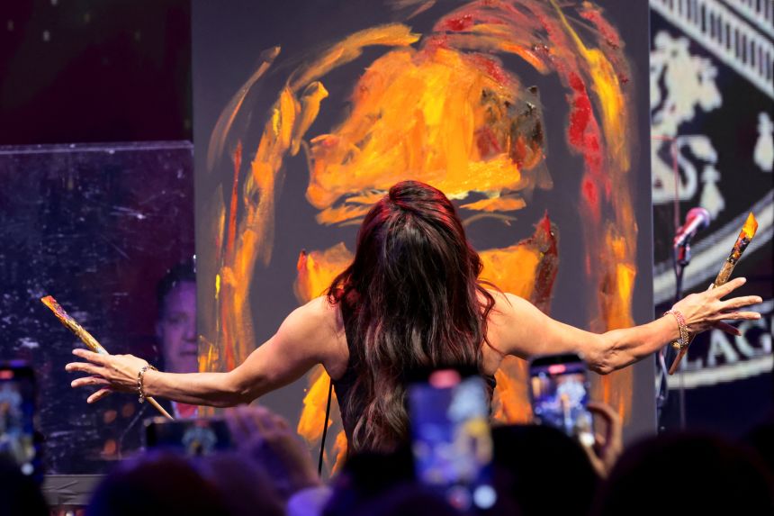 Artist Vanessa Horabuena paints on stage during a New Year's Eve party with US President Donald Trump at his Mar-a-Lago Club in Palm Beach, Florida, on December 31, 2025.