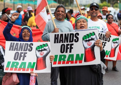 Protesters hold posters during a solidarity protest outside the U.S. embassy for the people of Venezuela, Iran and Palestine, in Cape Town, South Africa, January 22, 2026.