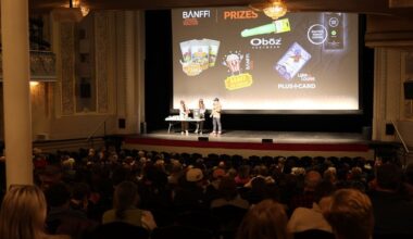 Hosts giving away prizes on stage at a theater.