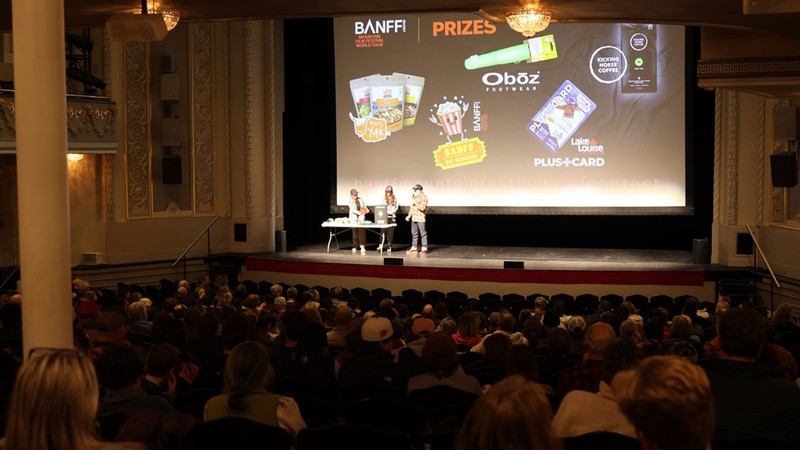 Hosts giving away prizes on stage at a theater.