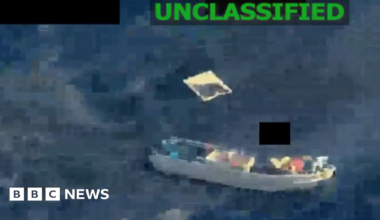 A screengrab from a video posted by US Southern Command shows a small vessel in the sea with what appears to be debris floating nearby. The word "unclassified" has been printed on top of the footage.