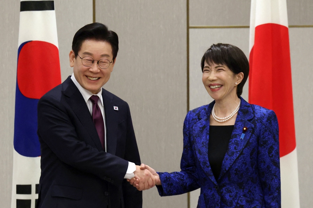 Japan’s Prime Minister Sanae Takaichi (R) shakes hands with South Korea’s President Lee Jae Myung at the start of their meeting in Nara, Nara Prefecture on January 13, 2026.