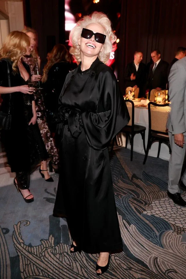 Getty She wore a draped black coatdress with her new hair