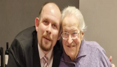 Prime Minister Mark Carney, wearing a black suit jacket, and a white button-up shirt leans his chin on his hands. He has short grey and black hair and is looking away from the camera.
