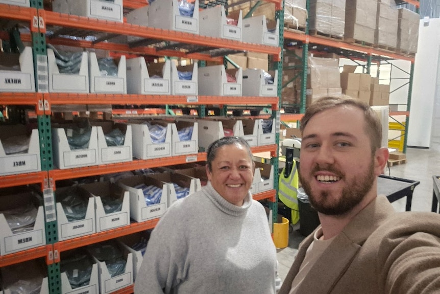 Selfie of a man and woman inside a big warehouse 