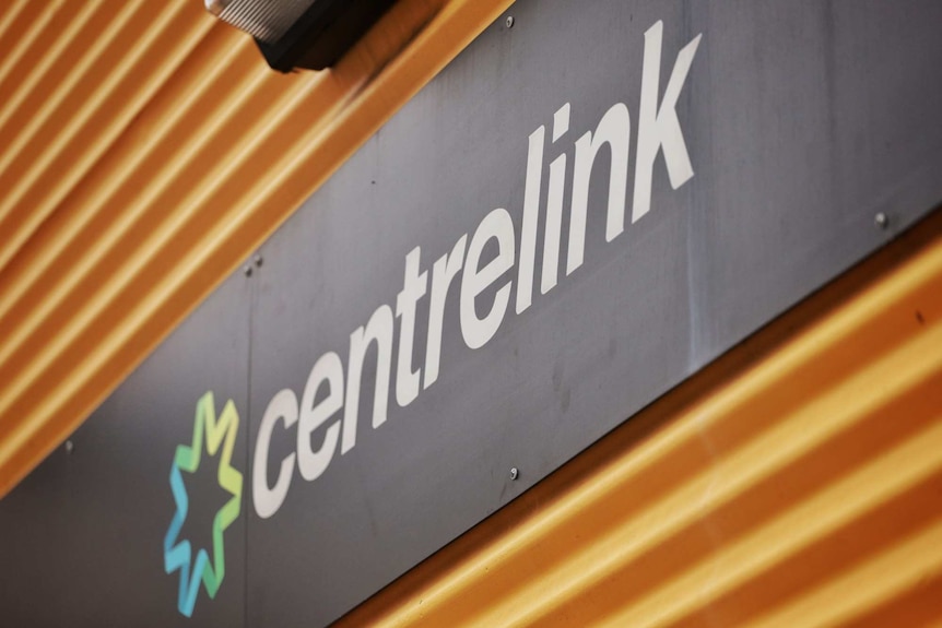 A Centrelink sign mounted on a wall.
