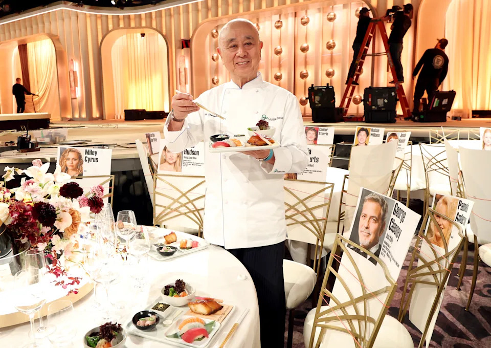 Chef Nobu Matsuhisa holds a platter of sushi in the room where the Golden Globes will be held