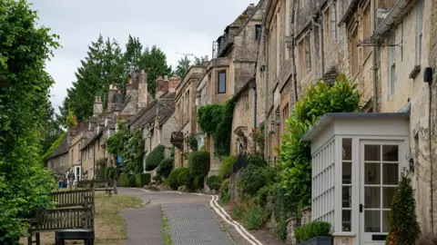 Getty Images View of a street lined with properties and greenery in the town of Burford, UK.