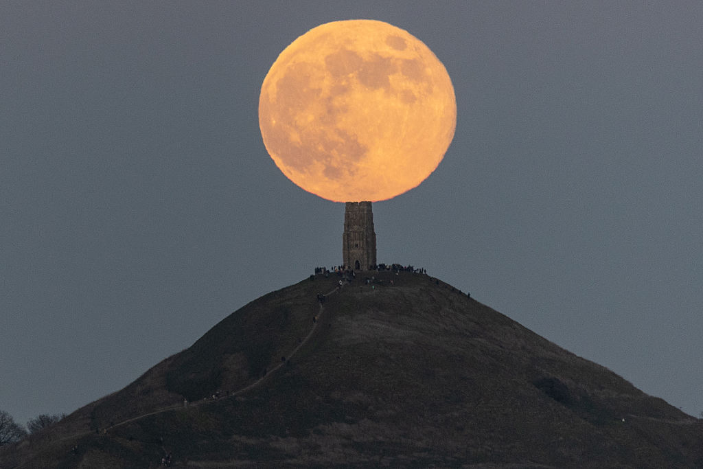 The Wolf Moon appears to rest on a church tower atop a hill in Glastonbury in the U.K.