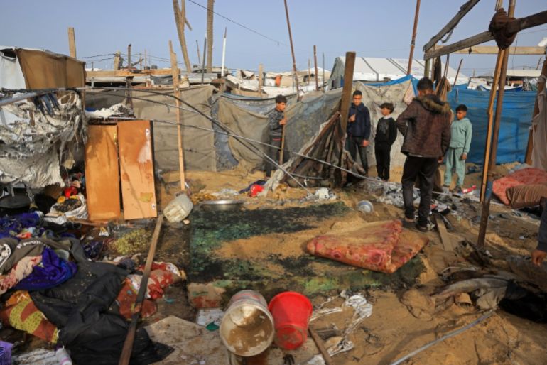 People inspect one of the tents, housing displaced Palestinians in the Mawasi area of Khan Yunis, in southern Gaza Strip, on January 30, 2026, following Israeli strikes. The US-brokered ceasefire, which sought to halt the fighting between Israel and Hamas sparked by the group's October, 2023 attack has been in place for more than three months despite both sides accusing the other of repeated violations.