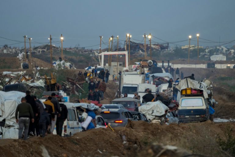 improvised lights surround cars driving through piles of dirt near a checkpoint