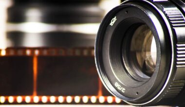 Close-up of a camera lens with a blurred film strip in the background, evoking a sense of photography and analog film.