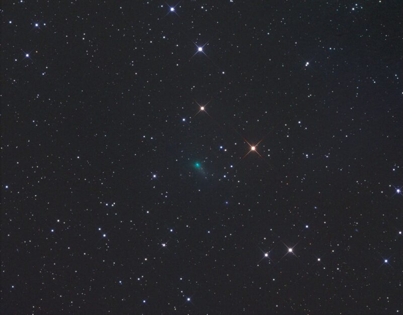 Bluish green fuzzy spot in a field of stars.