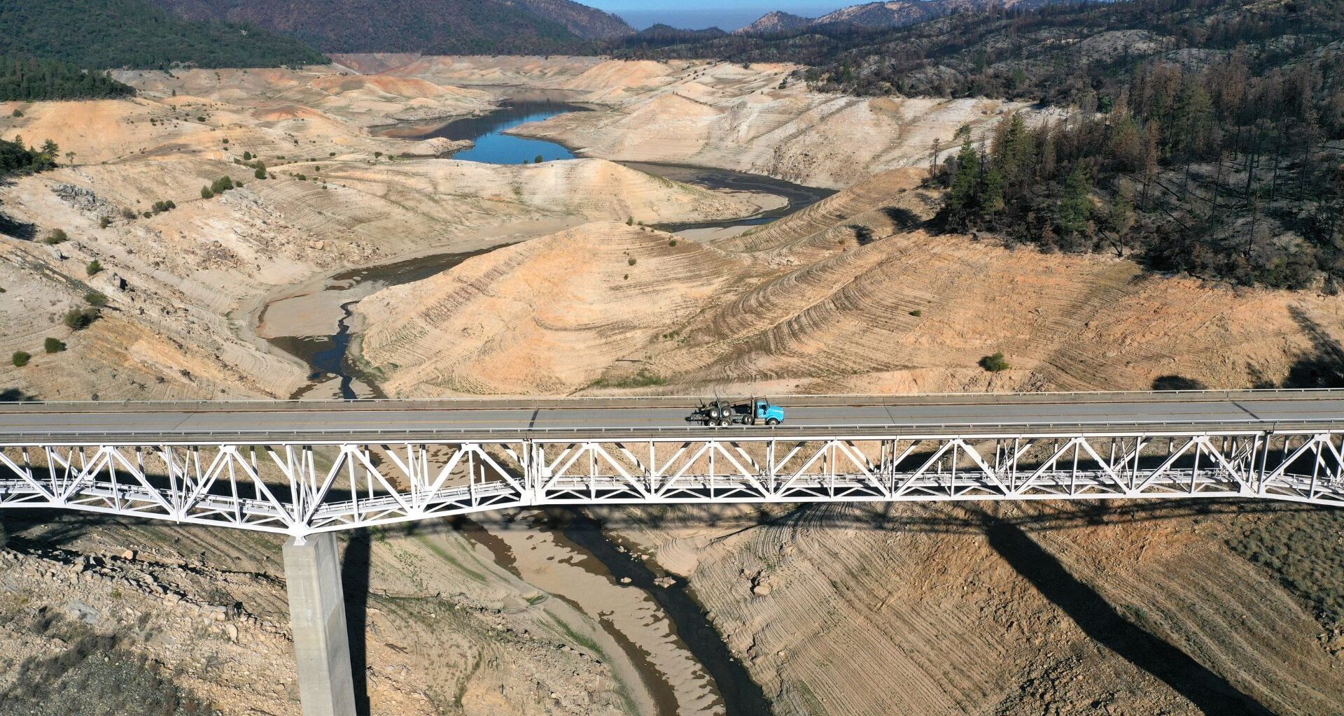 Aerial photo of a bridge over a large, mostly dry lake bed.