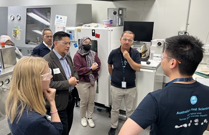 Seven people talking in a laboratory