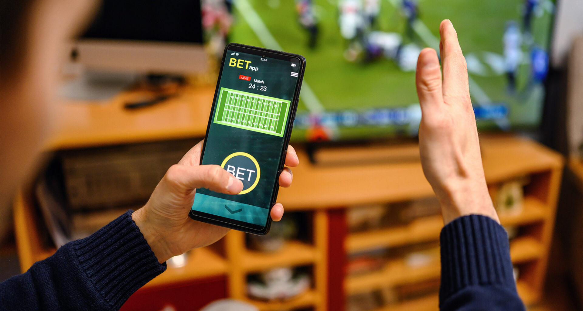 Man using betting app on his smartphone.