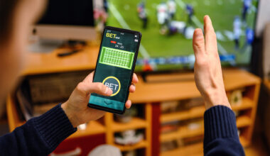 Man using betting app on his smartphone.