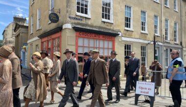 Behind the scenes photo of Netflix's Agatha Christie’s Seven Dials, featuring people in period dress.
