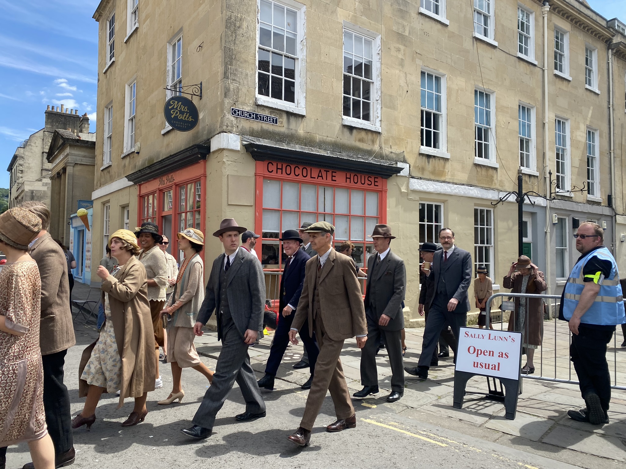 Behind the scenes photo of Netflix's Agatha Christie’s Seven Dials, featuring people in period dress.