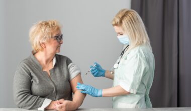 Older adult getting immune vaccine in arm for flu shot in hospital by nurse.