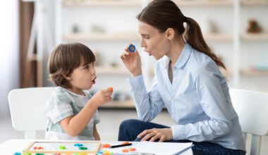 Little boy learning letter O with private English language tutor during lesson at office