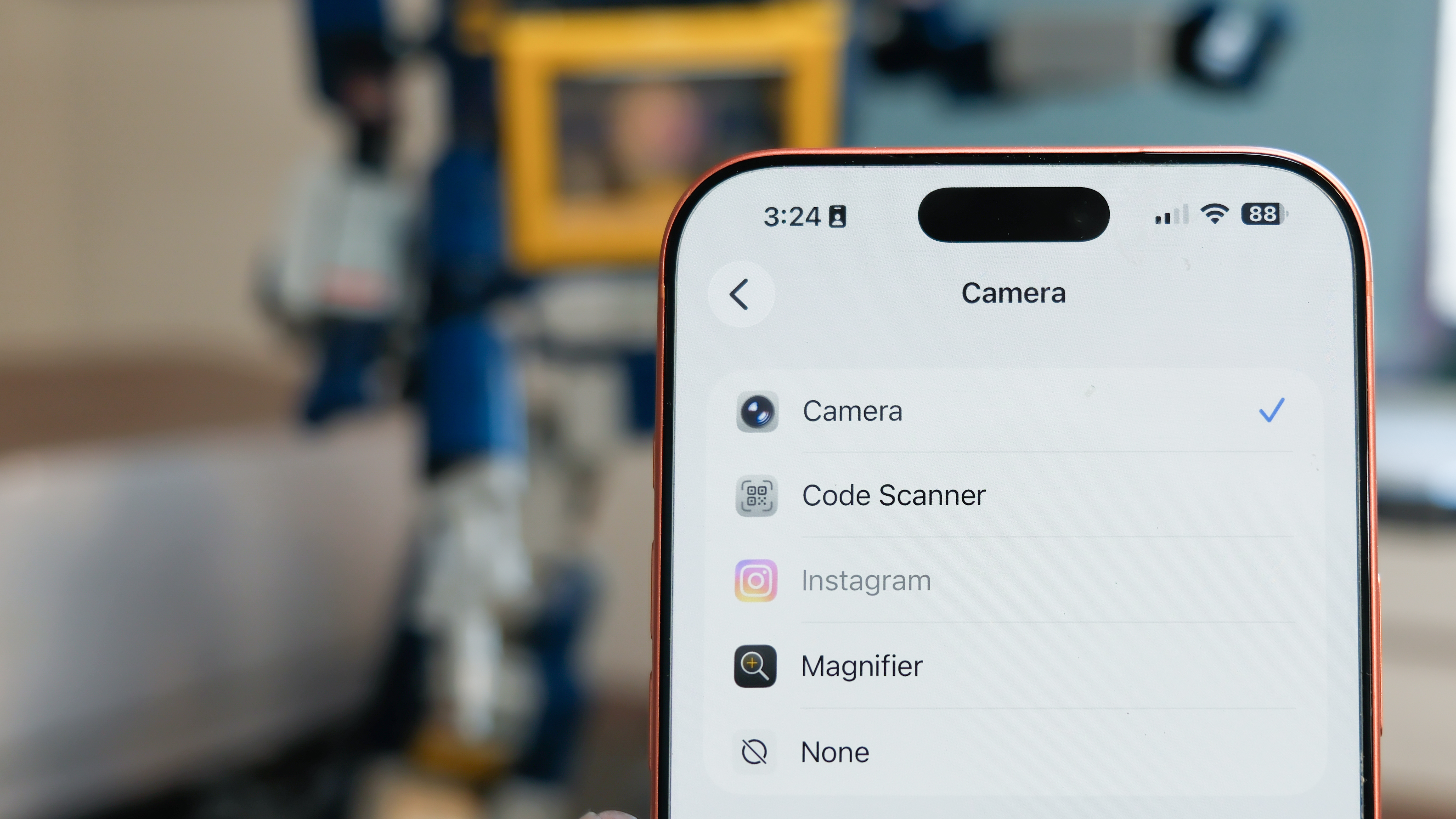 Camera Control button software features on the Apple iPhone 17 Pro Max in Cosmic Orange color, showing zoom, switching cameras, Magnifier app, and more