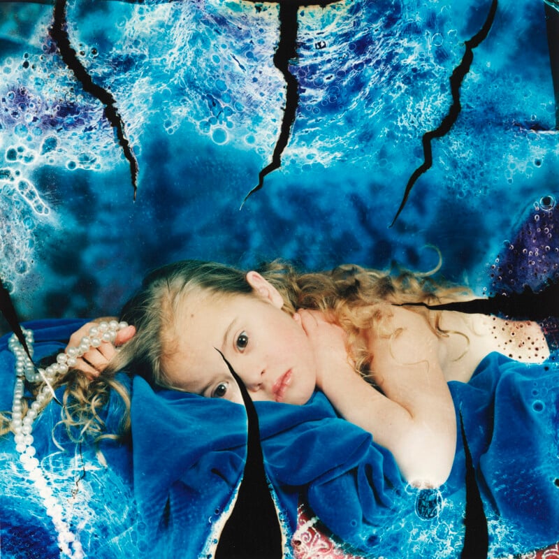 A girl lying on a blue blanket.