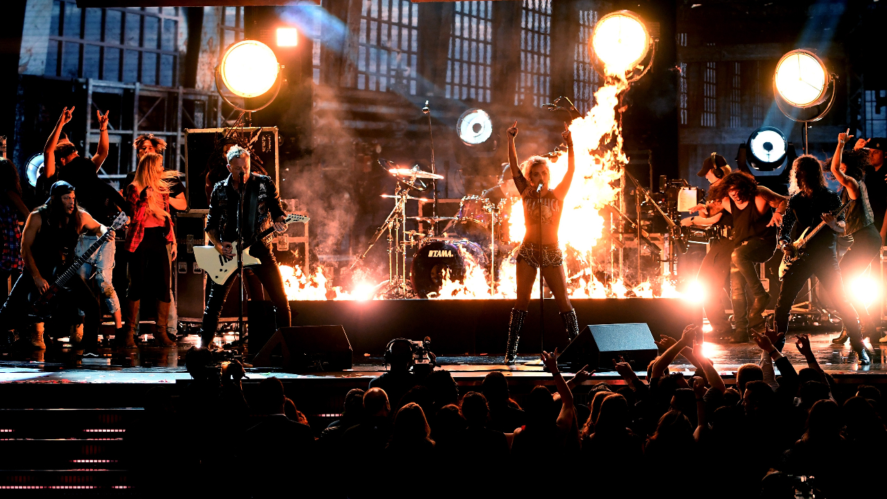 Metallica and Lady Gaga on stage surrounded by flame