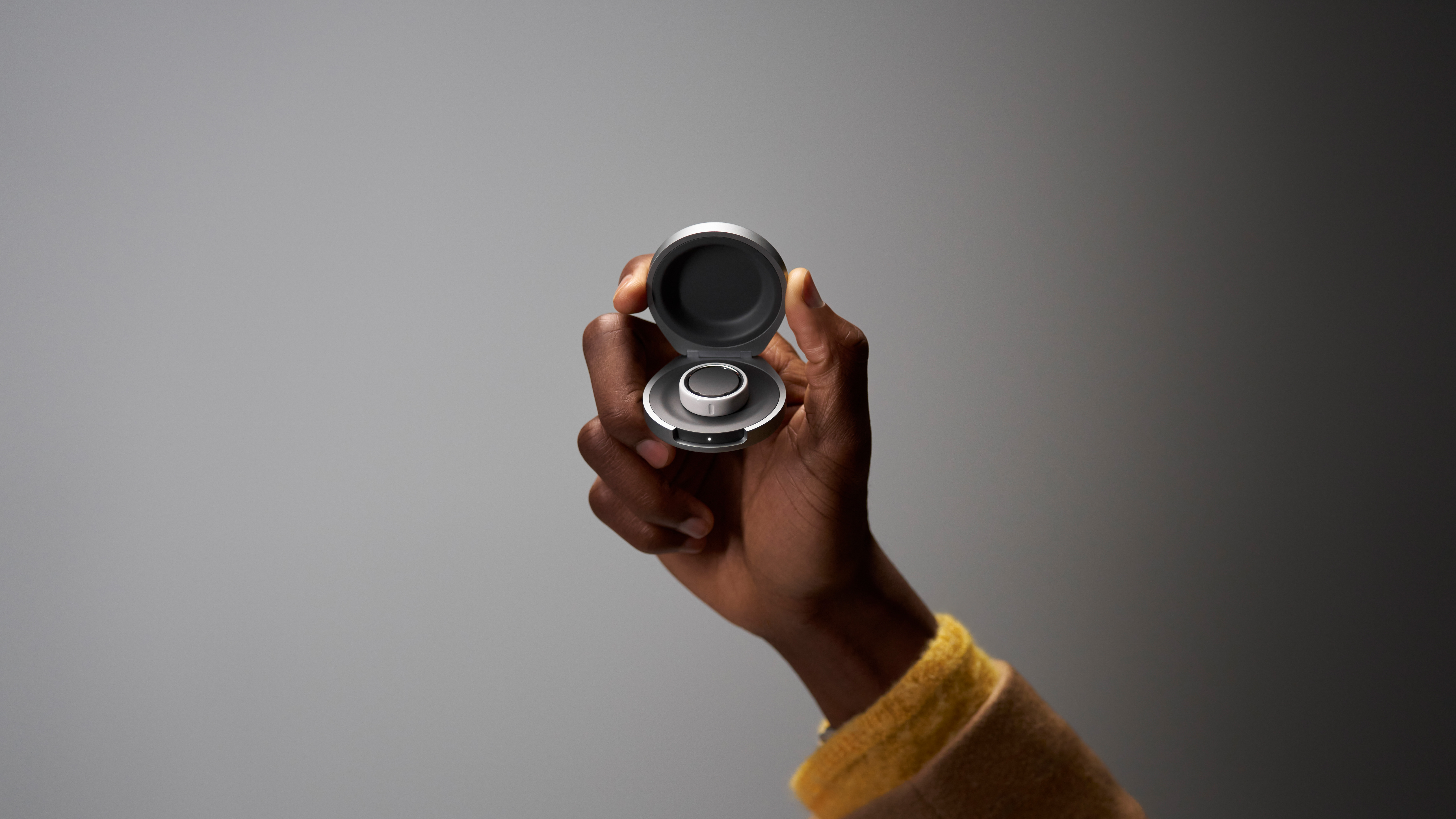 Oura Ring Charging Case An Oura Ring user holds their Oura Ring Charging Case in hand.