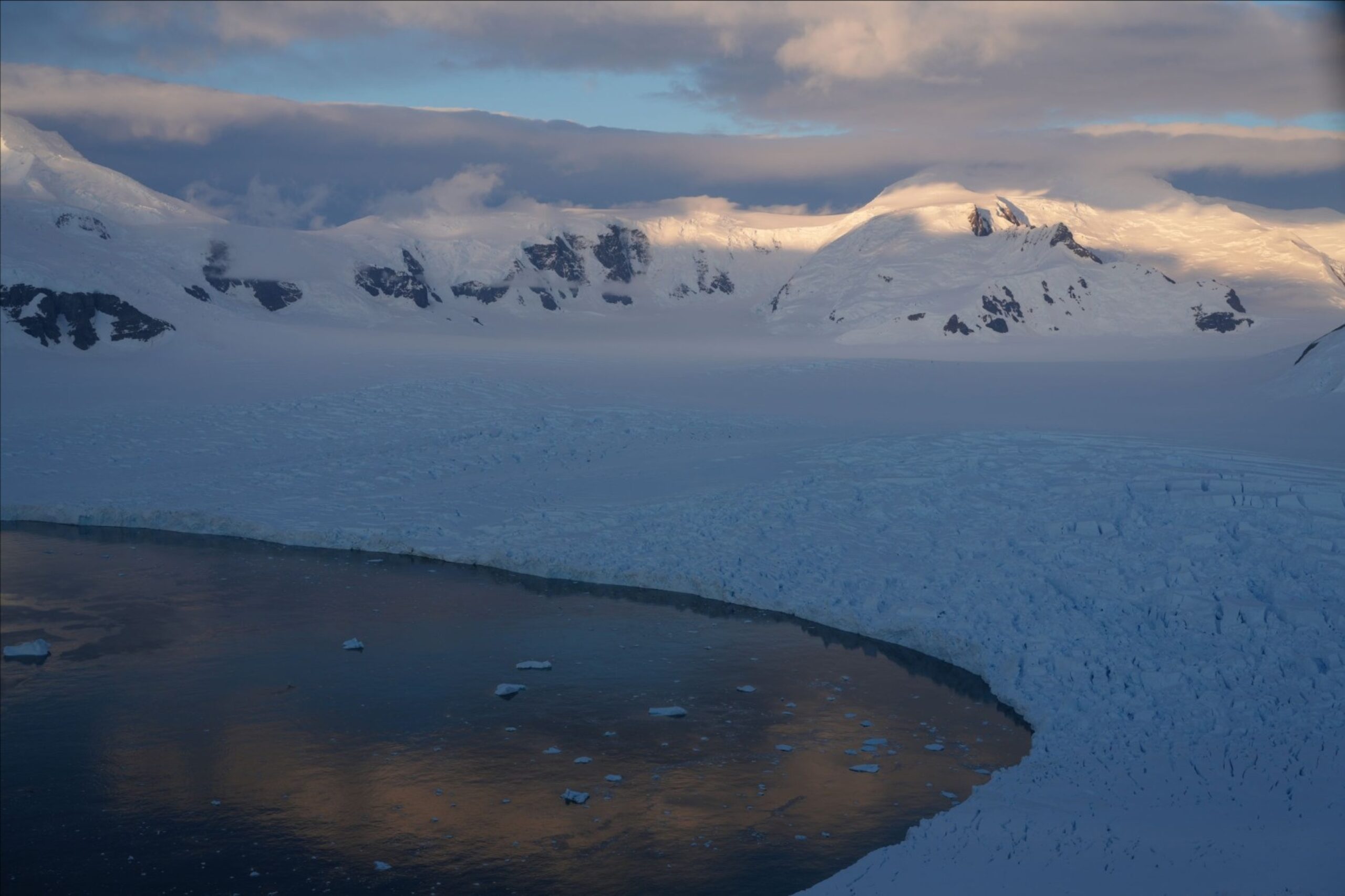 A view over a curved snowy bay