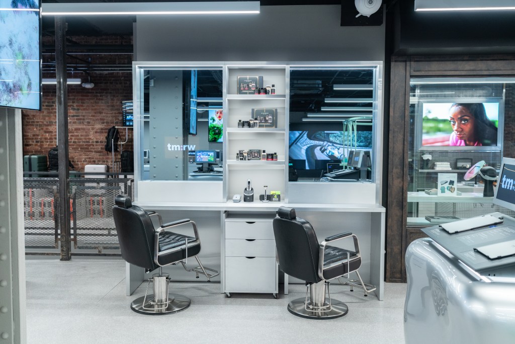 Two black salon chairs in front of two interactive mirrors at the tm:rw store.