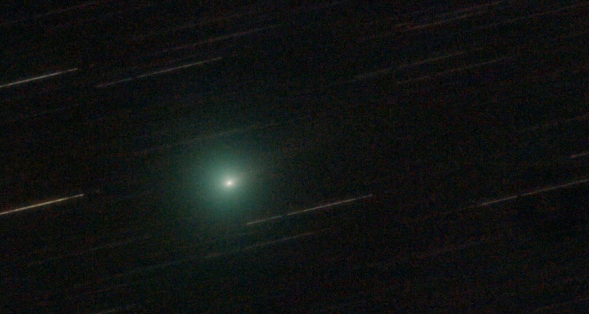 a fuzzy green blob on a black background crossed with white streaks