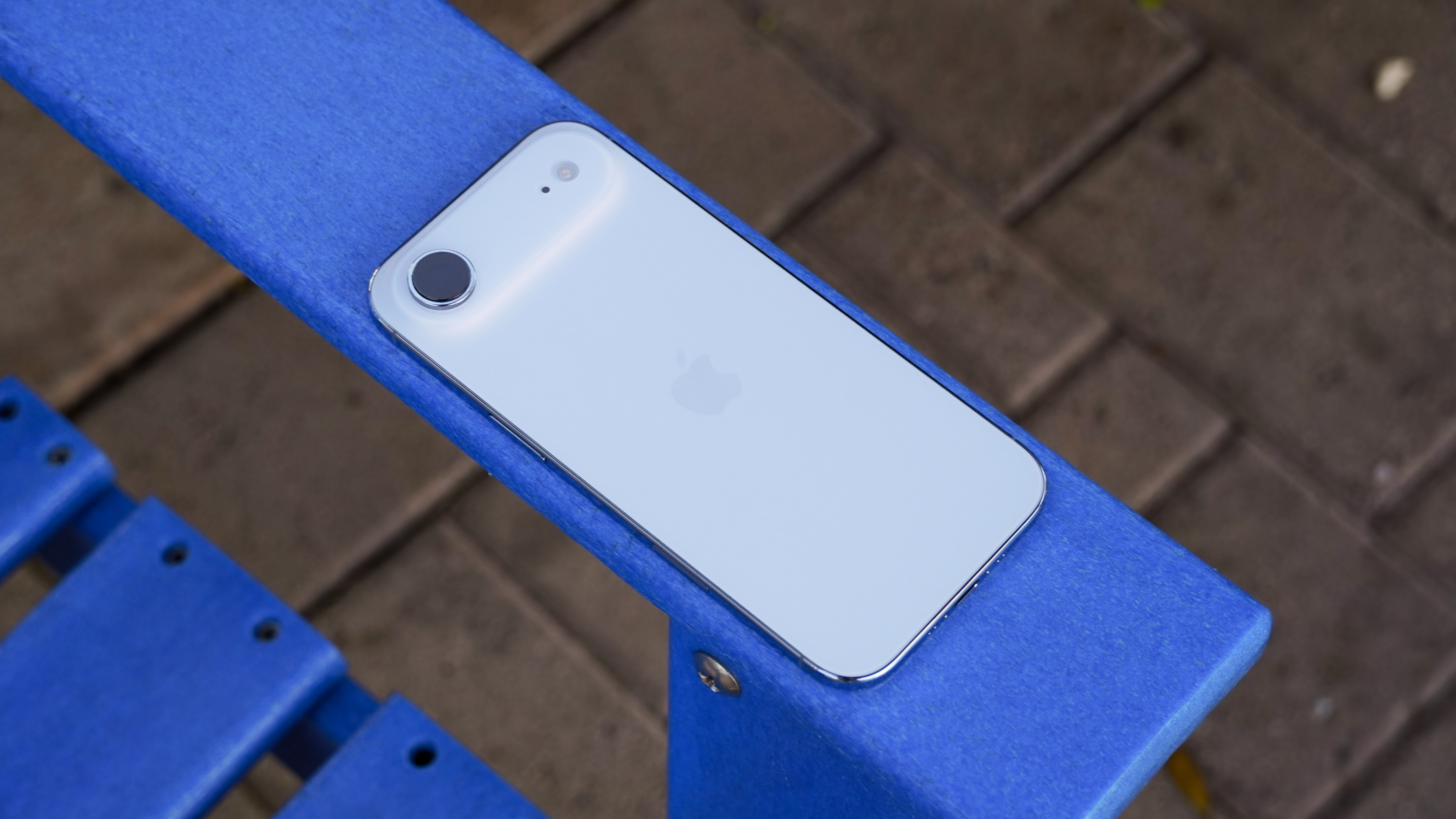 The back of an iPhone Air in Sky Blue on a blue chair.