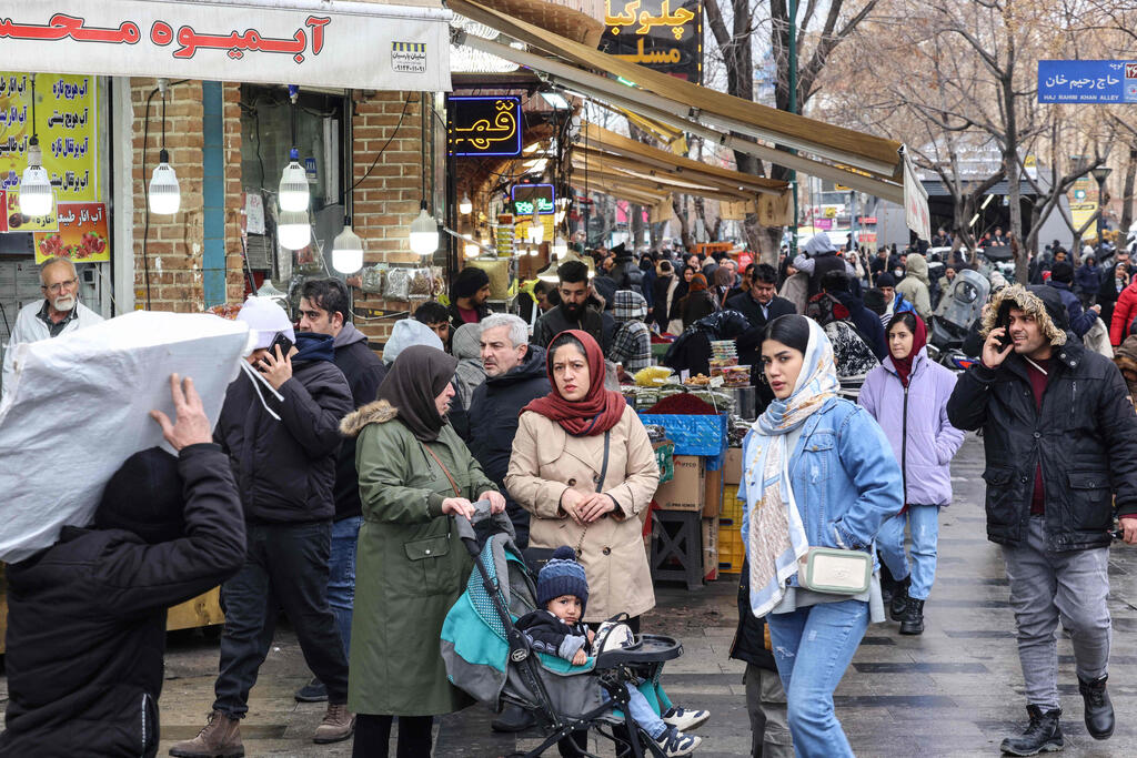Iranians shopping for food at the bazaar in Tehran (Photo: ATTA KENARE / AFP) איראן קונים חנויות ליד ה בזאר ב טהרן