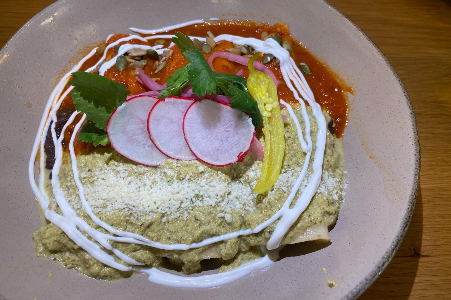 A plate of enchiladas topped with radish slices.
