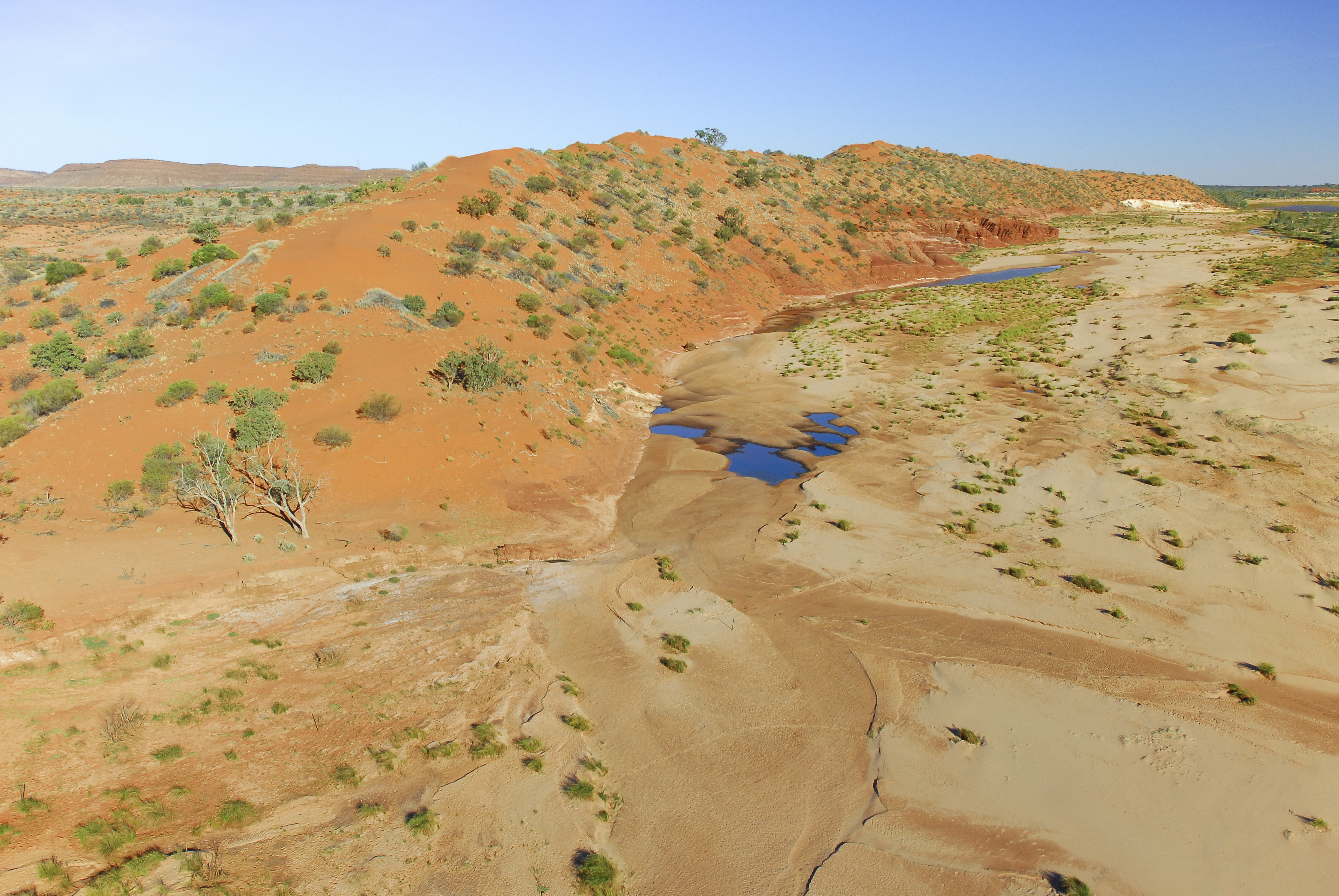 A few stretches of blue in a desert covered by scrubby plants.