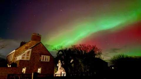 3TSMUM/BBC WEATHER WATCHERS Green streak of Northern Lights over a house in Trinity 